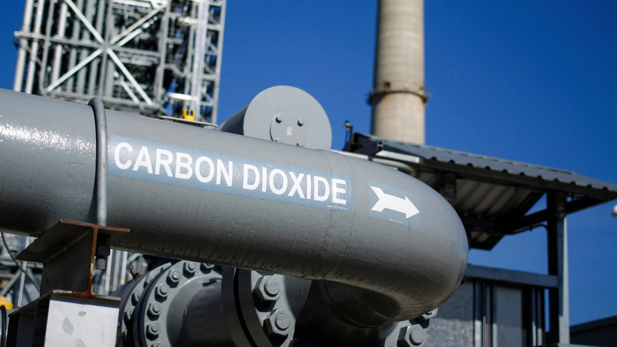 CO₂ pipeline labeled carbon dioxide at industrial facility under blue sky