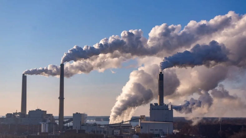Industrial facility with smokestacks releasing emissions into the air